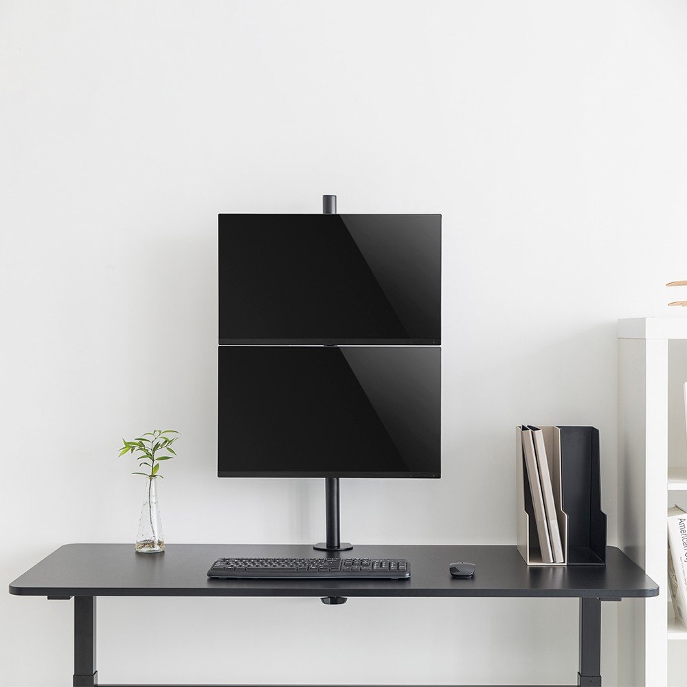Suporte para monitor instalado em mesa de trabalho pequena, otimizando espa&ccedil;o.